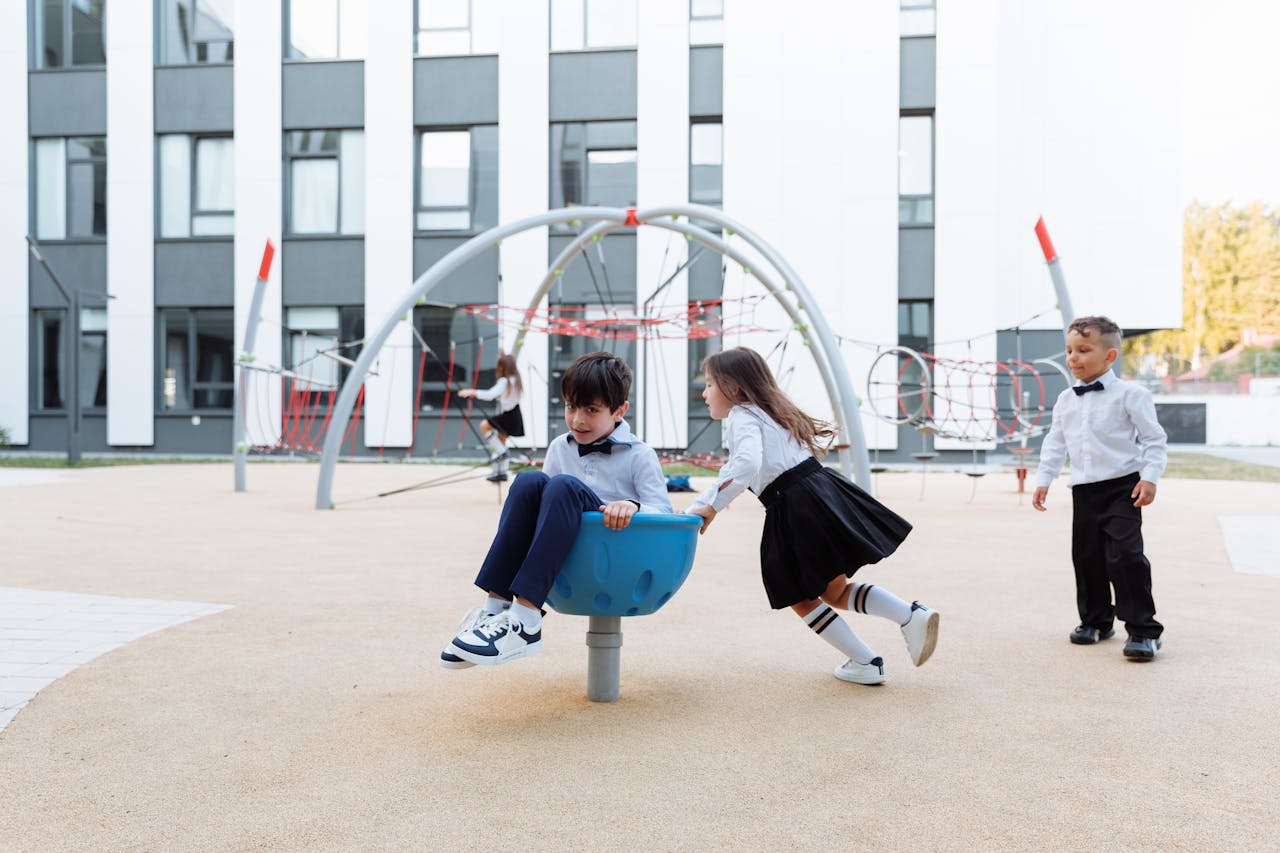 Joyful children having fun together in a modern outdoor playground area, dressed in formal clothing.